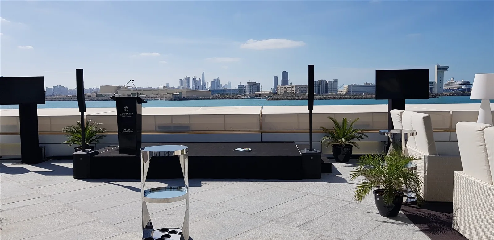Outdoor speakers and lectern arranged for a waterfront event